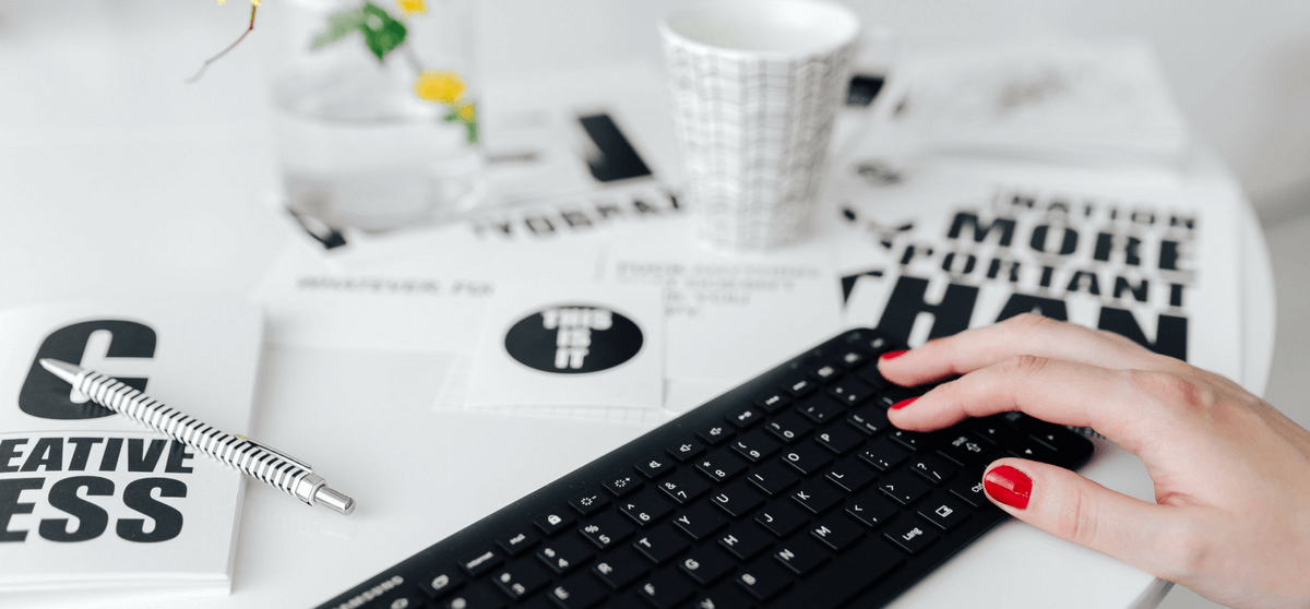 runder weißer Tisch, auf dem eine Tastatur, eine Tasse und Karten liegen