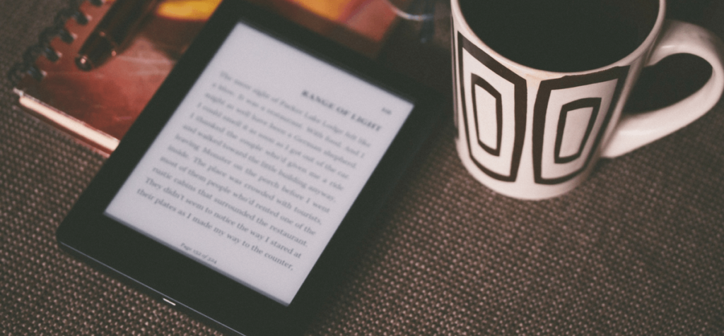 eBook Reader mit Notizheft und Kaffeetasse