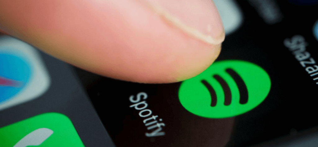 Finger tippt Spotify App am iPhone an