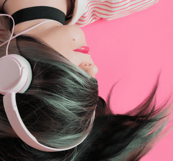 Frau mit Kopfhörern auf pinkem Hintergrund