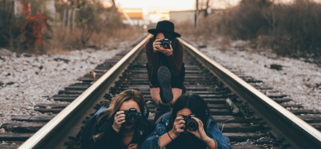 3 Fotografinnen auf Eisenbahnschienen