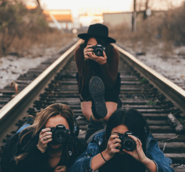 3 Fotografinnen auf Eisenbahnschienen